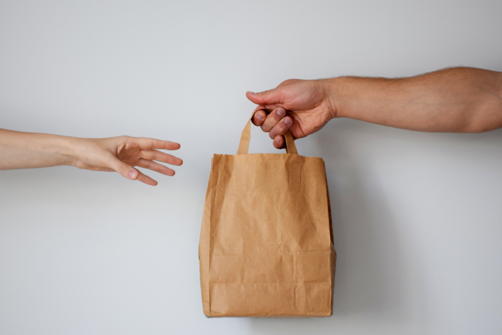 Hand reaching for unmarked, brown bag delivery 