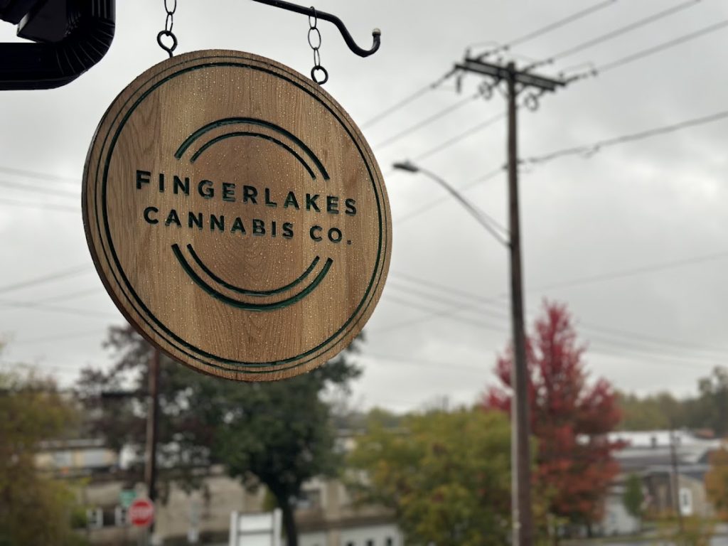 Sign reading “FingerLakes Cannabis Co.” hangs on the street