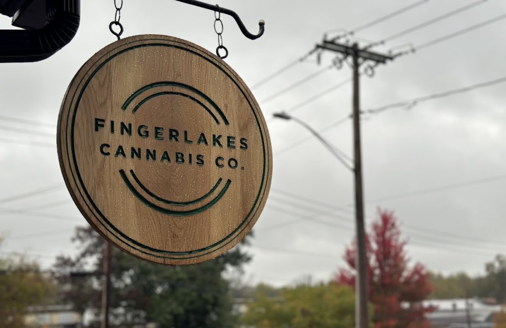 Sign reading “FingerLakes Cannabis Co.” hangs on the street