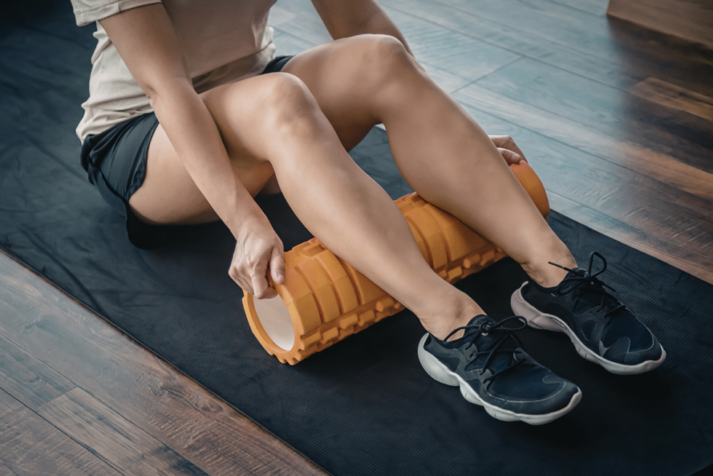 Athlete rolling calves out with foam roller